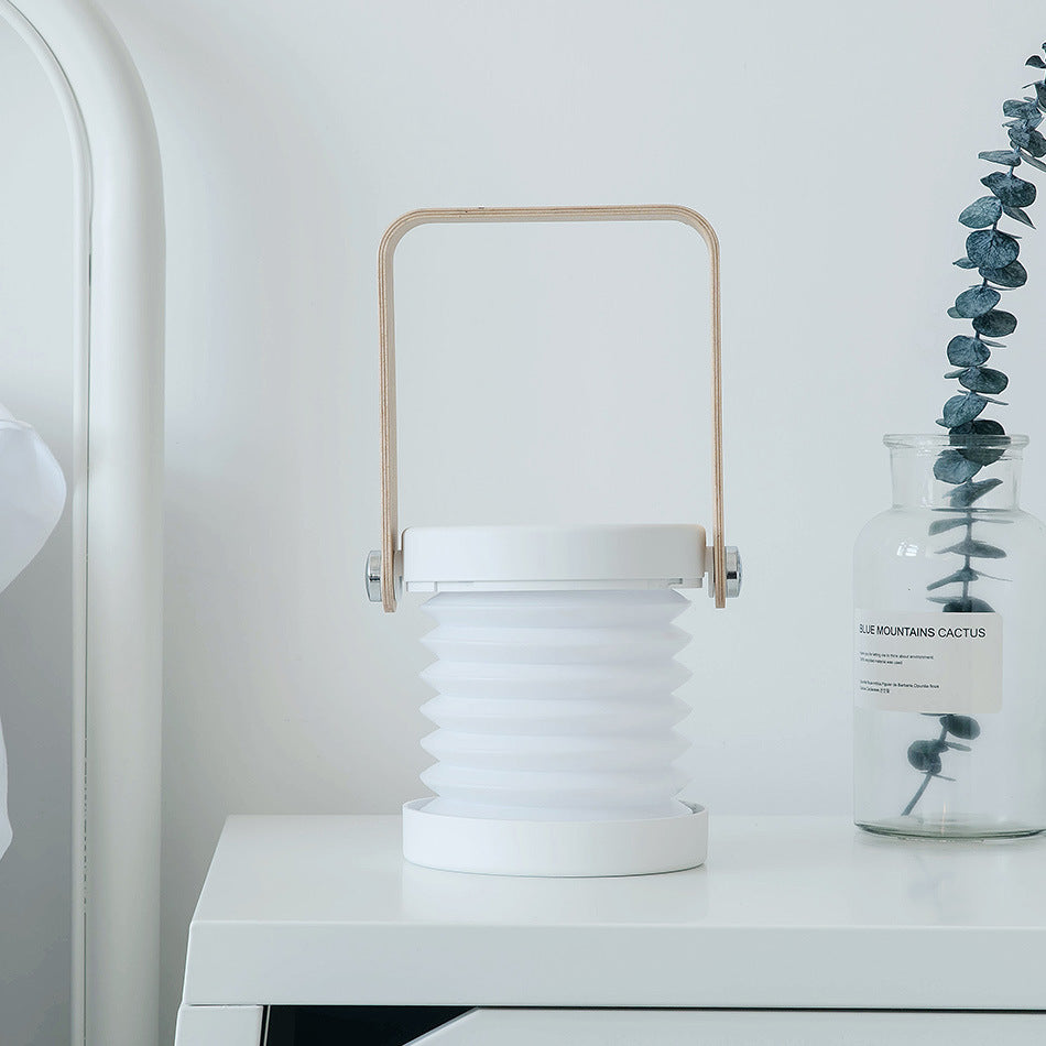 Cordless folding lantern standing open as a warm bedside reading light