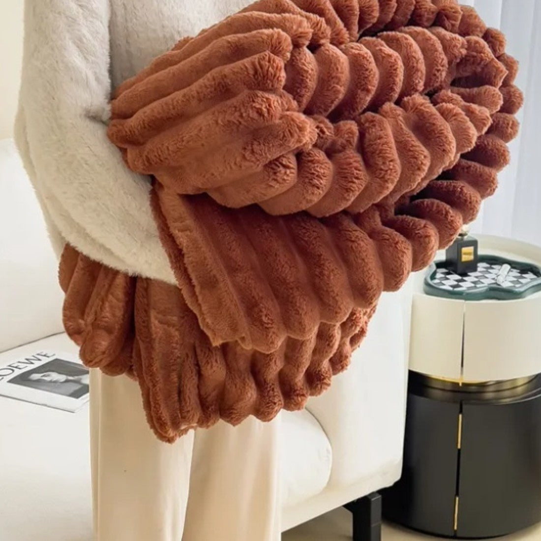 Bubble Plush Throw in caramel, folded over an arm
