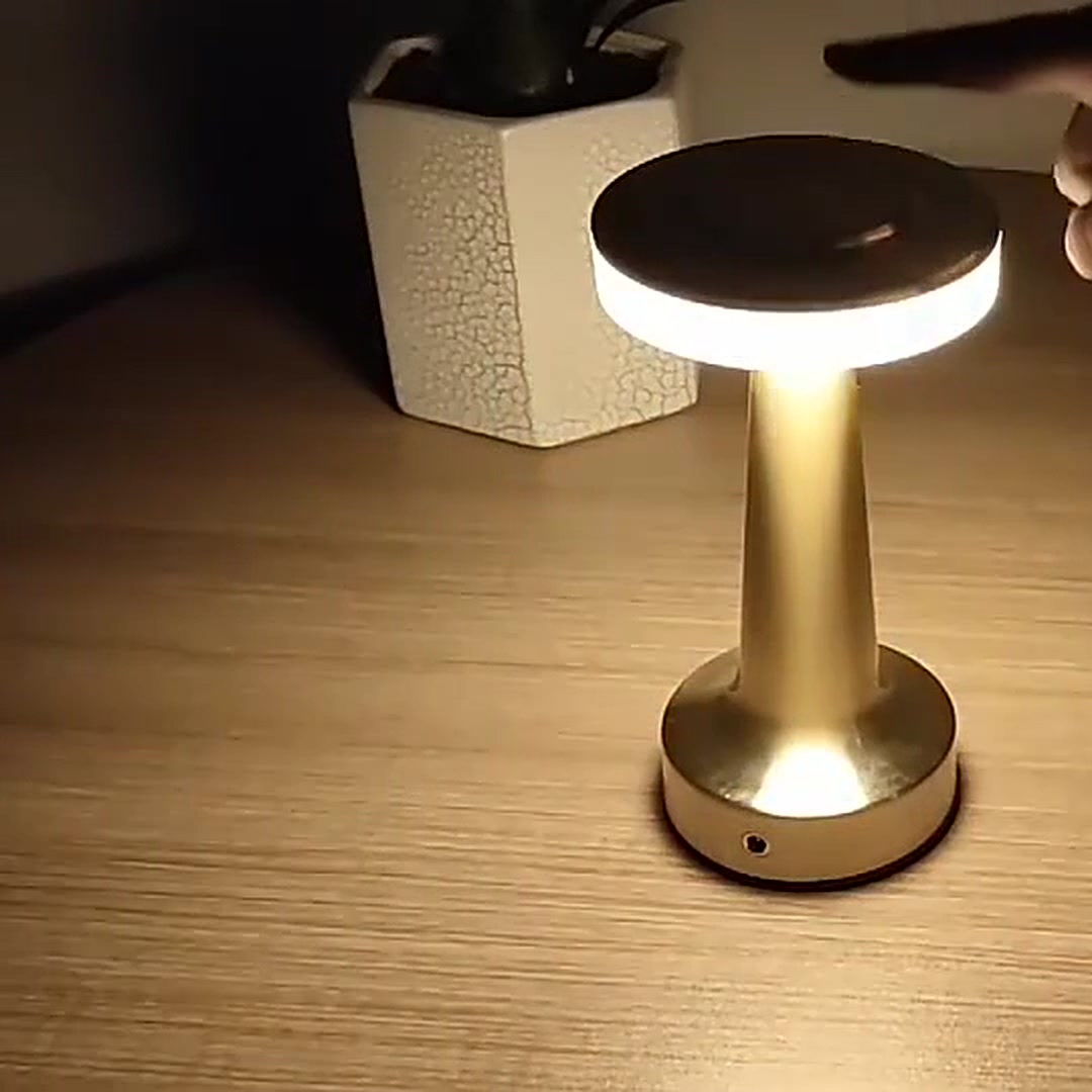 Cordless Table Lamp in gold, lit in a dark room