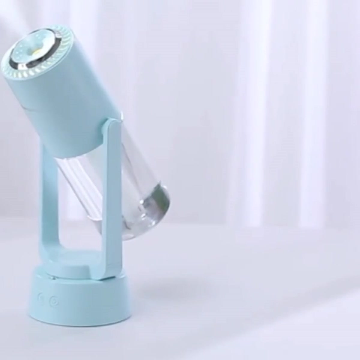 Night Mist Projector in light blue on a white table