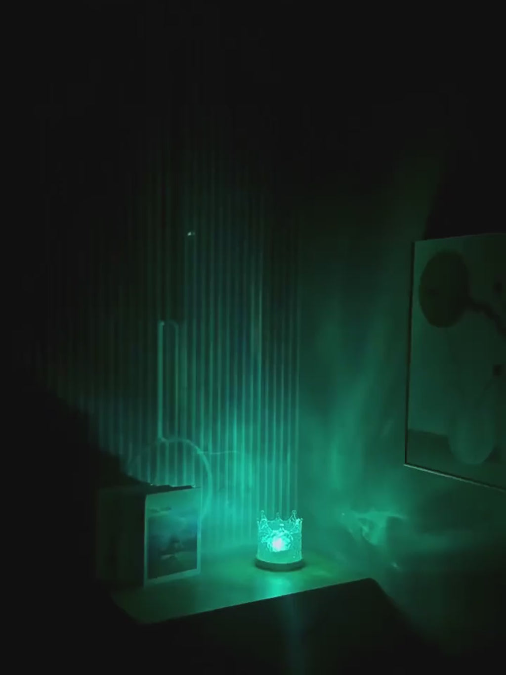 Crown water ripple lamp in a dark room, moving water light on the wall as it changes colour