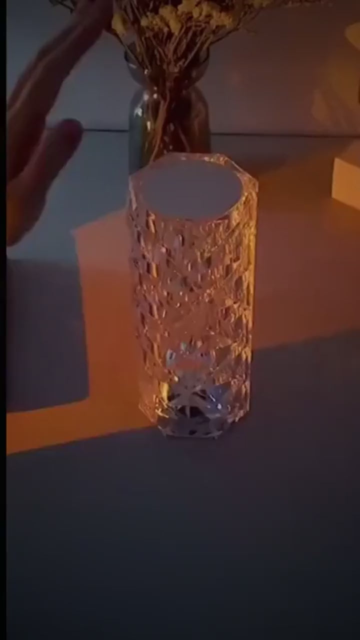 Crystal Rose Lamp changing colour at a touch, casting a rippled light pattern on the table