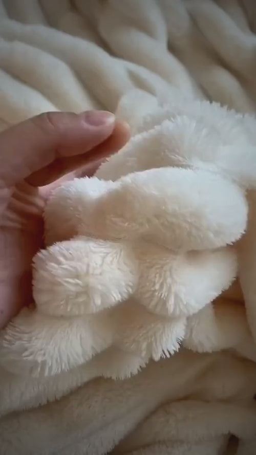 Bubble Plush Throw in milky white: the raised bubble texture up close and on a sofa